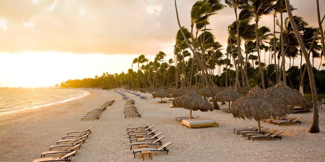 Playa Bávaro con palapas y tumbonas al atardecer